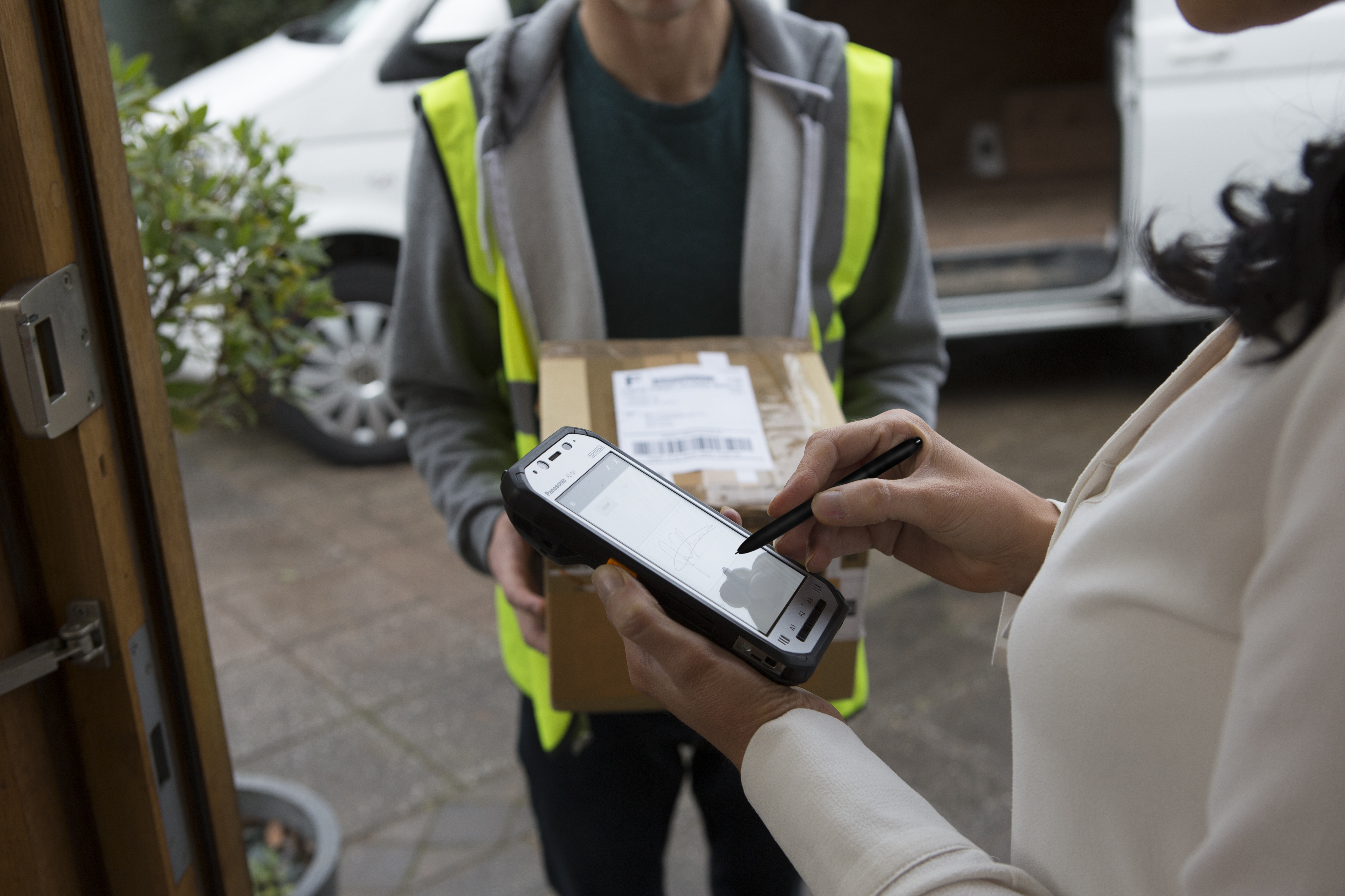 A messenger delivering a package using a handheld device that is managed and secured by SOTI's MDM solution