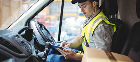 Delivery driver sitting in his truck and using his company issued tablet that is managed and secured by SOTI MobiControl